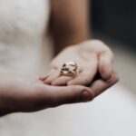 Bride holding wedding bands in a tender moment, symbolizing love and commitment.