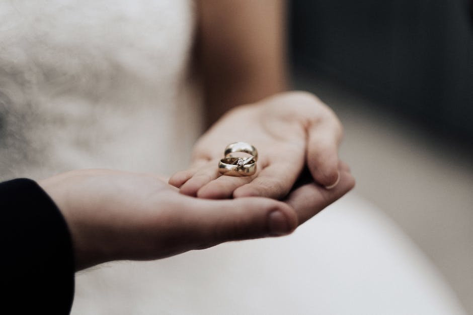 Bride holding wedding bands in a tender moment, symbolizing love and commitment.