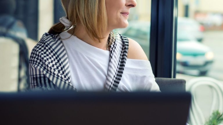 Lachende vrouw die uit een raam kijkt. Hopeloos verliefd