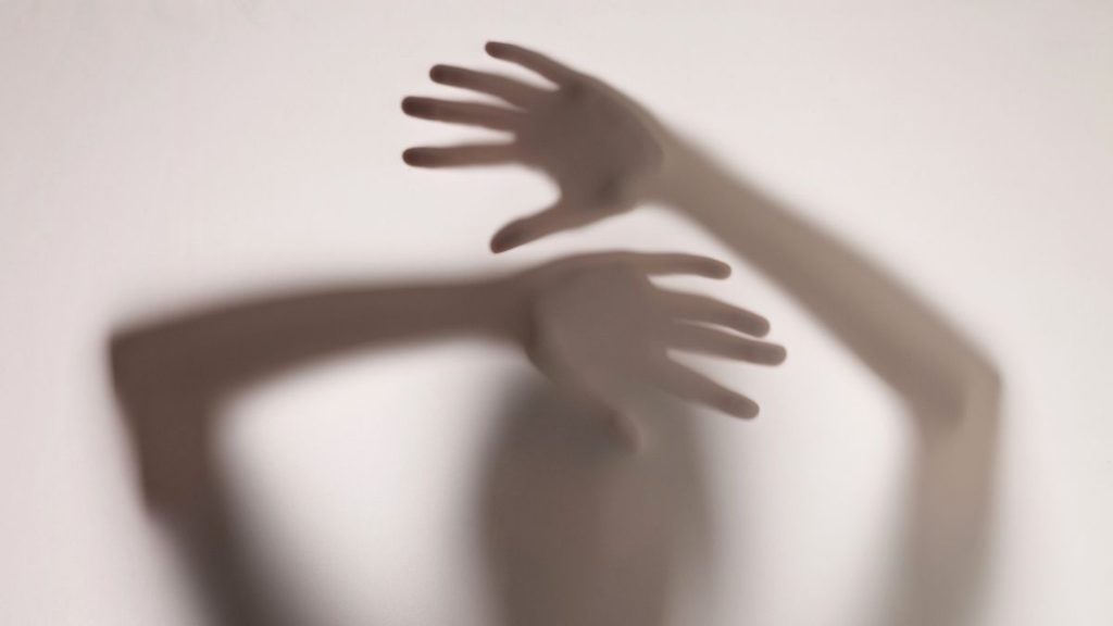 handen van een vrouw die tegen een elastisch scherm drukken