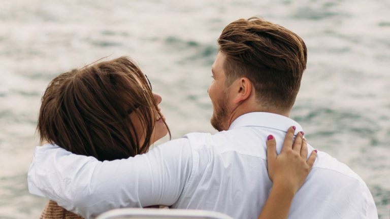 vrouw en man op een boot die elkaar aankijken en lachen