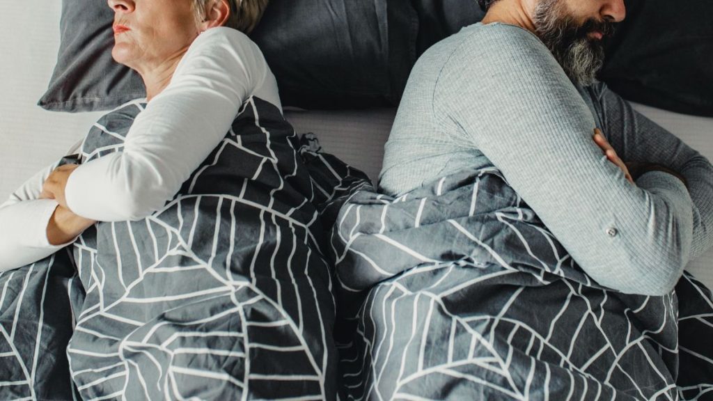 stel in bed met de rug naar elkaar toe