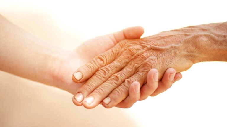 Een jongere die de hand van een oudere vasthoudt. Dit symboliseert generatieverschillen