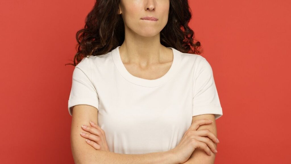 Vrouw met gekruiste armen en een bezorgde uitdrukking op haar gezicht