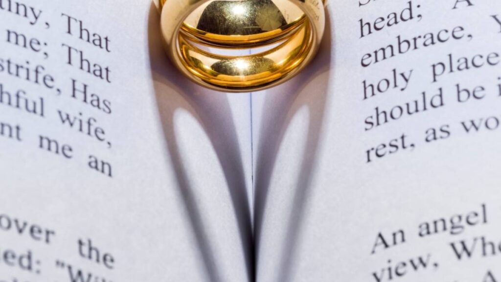 een ring die de schaduw van een hart op een boek werpt