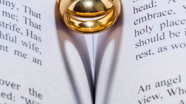 een ring die de schaduw van een hart op een boek werpt