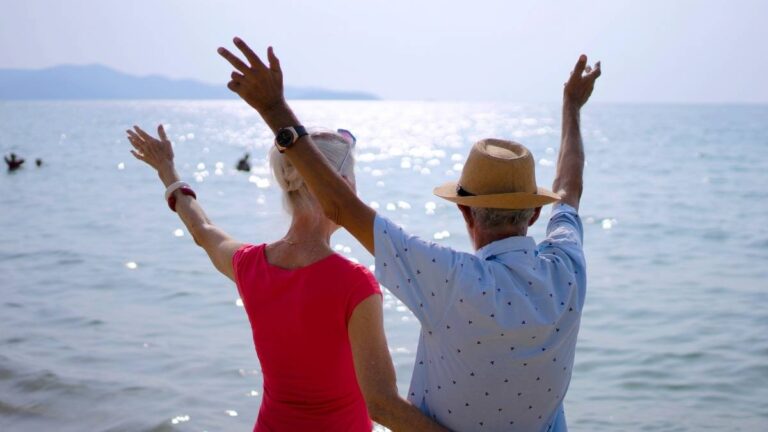 bejaard koppel dat hun armen omhoog heft