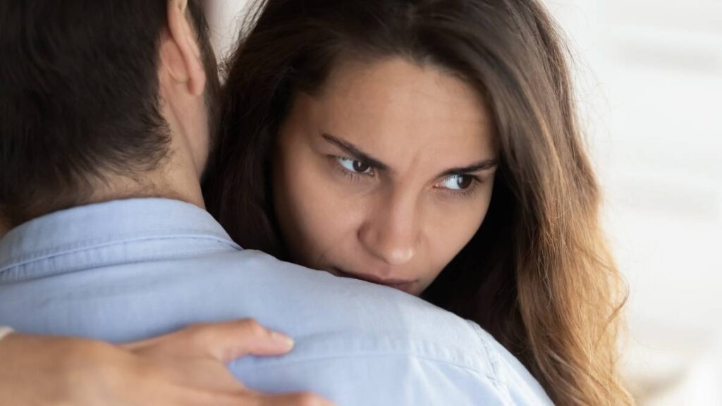 vrouw die een man omhelst, er geagiteerd uitziet