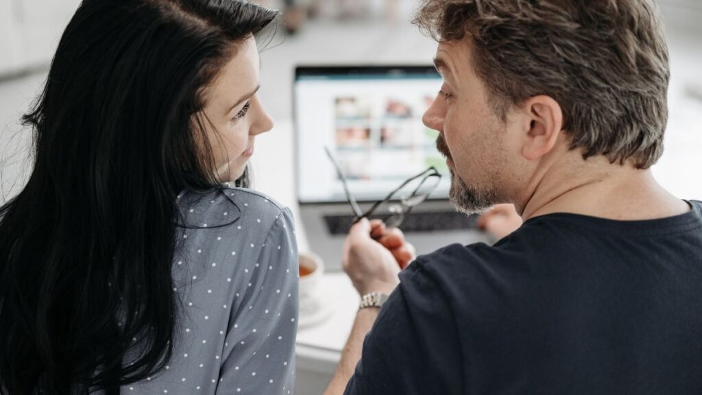 een stel dat met elkaar praten voor een laptop